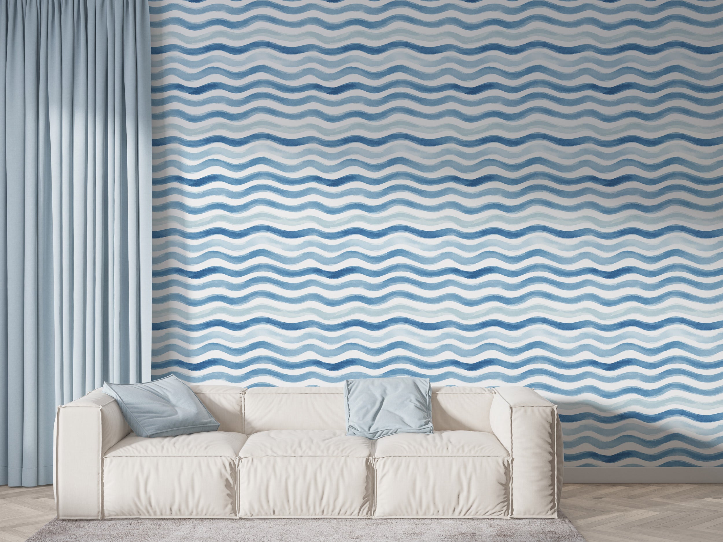 Blue watercolor wave pattern wallpaper with white accents in a living room setting behind a white sofa and light blue curtain