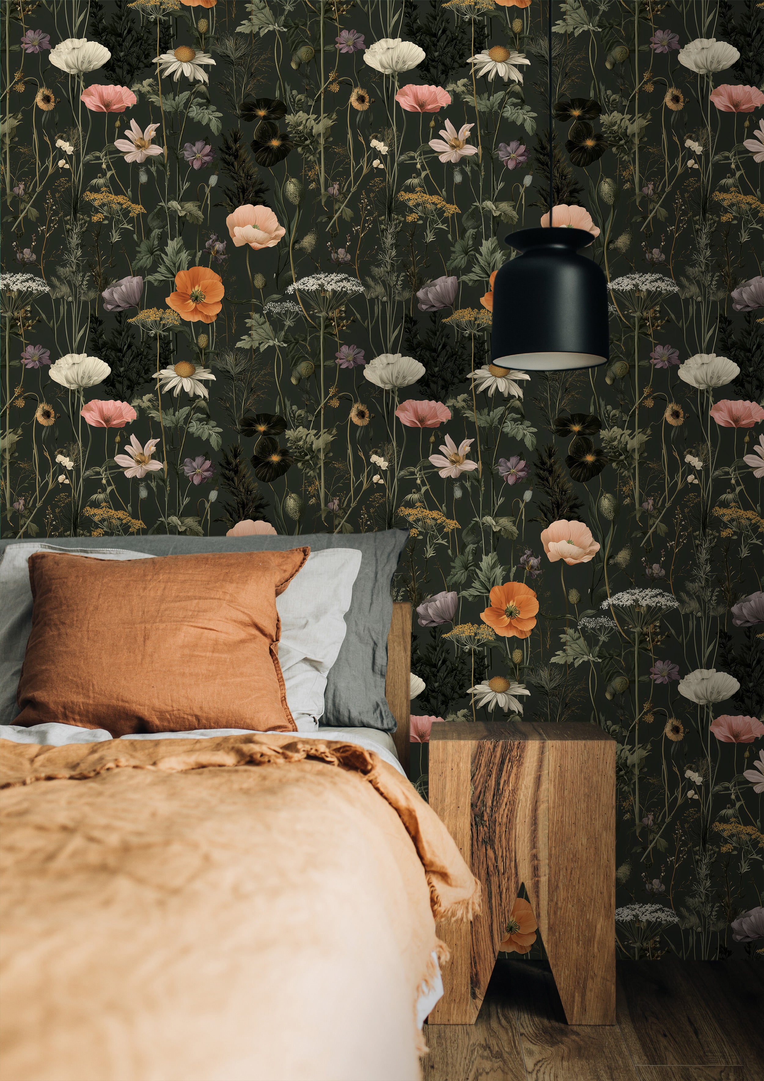 Dark green botanical wallpaper with wildflowers in a cozy bedroom, plants on a nightstand, warm orange bedding and a black ha