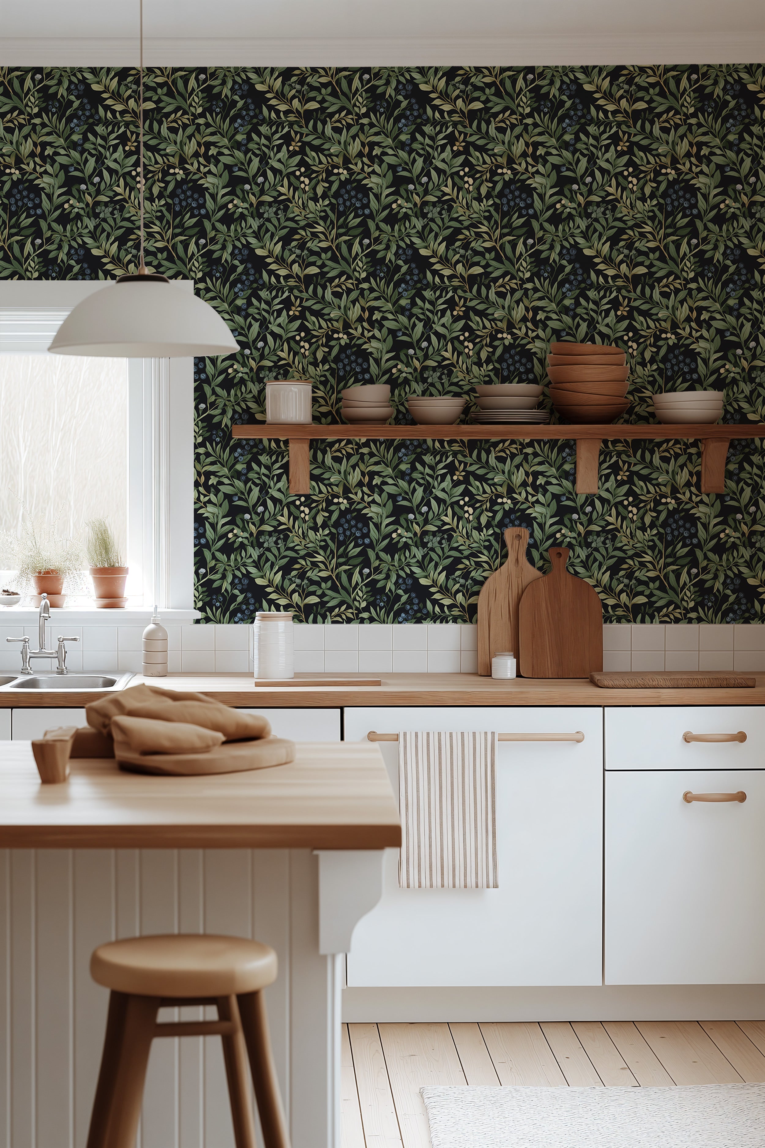 Black wallpaper with lush green blueberry leaves and berries in a bright kitchen setting with white cabinets and wooden accen