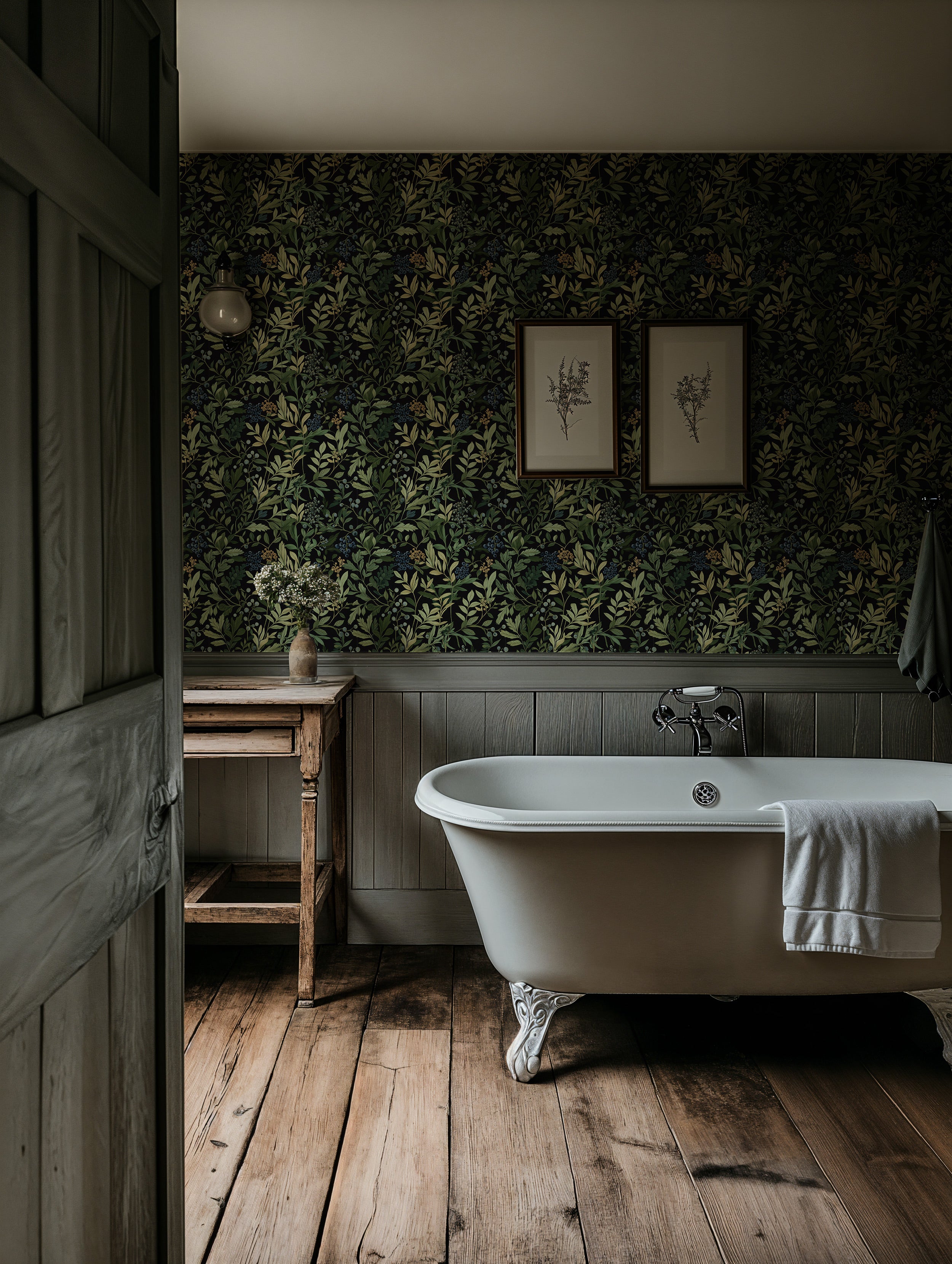Dark botanical berry wallpaper with green leaves and blue berries in a vintage bathroom featuring a white clawfoot tub and wo