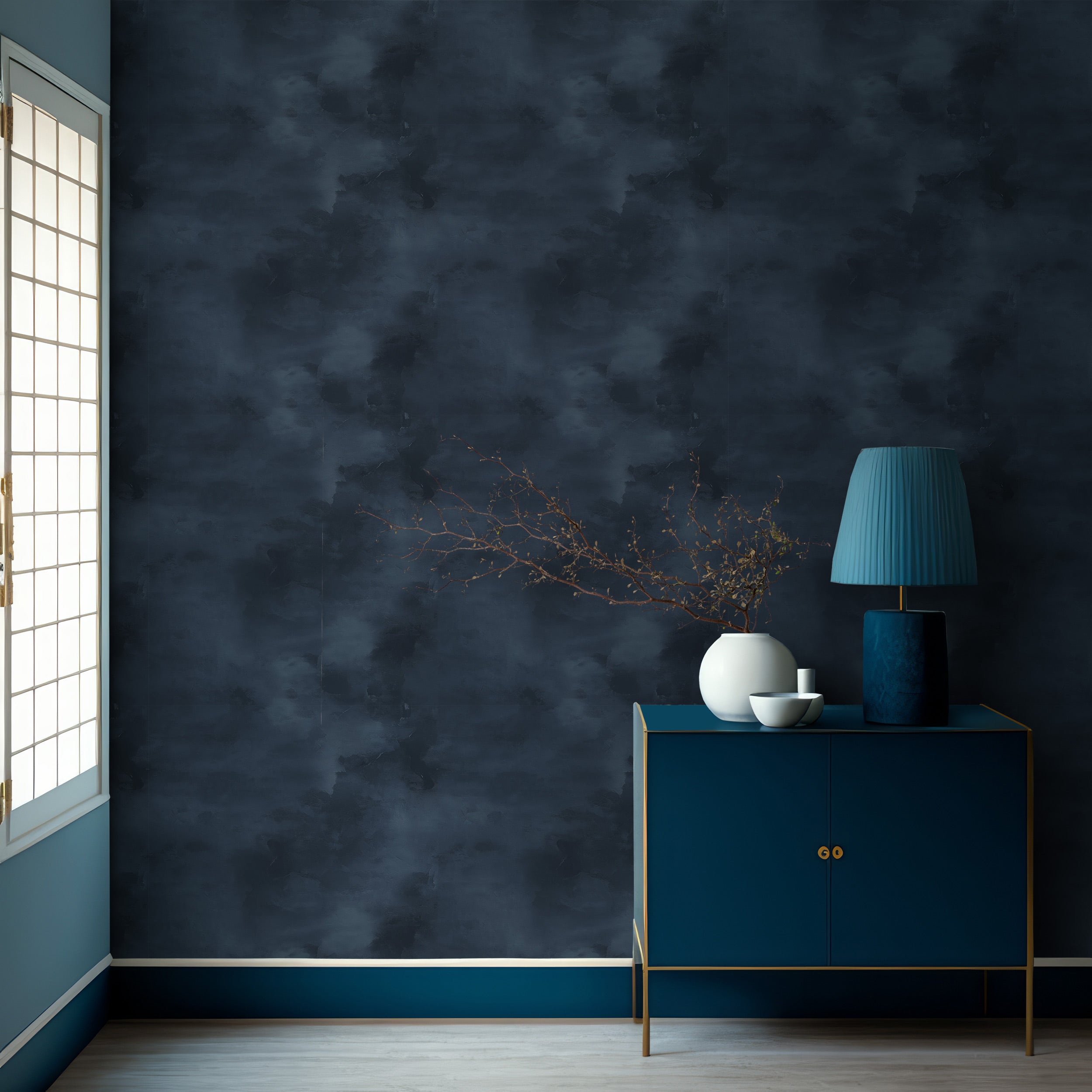 Navy blue abstract wallpaper with a textured pattern in a bedroom setup featuring a blue sideboard, teal lamp, and minimalist