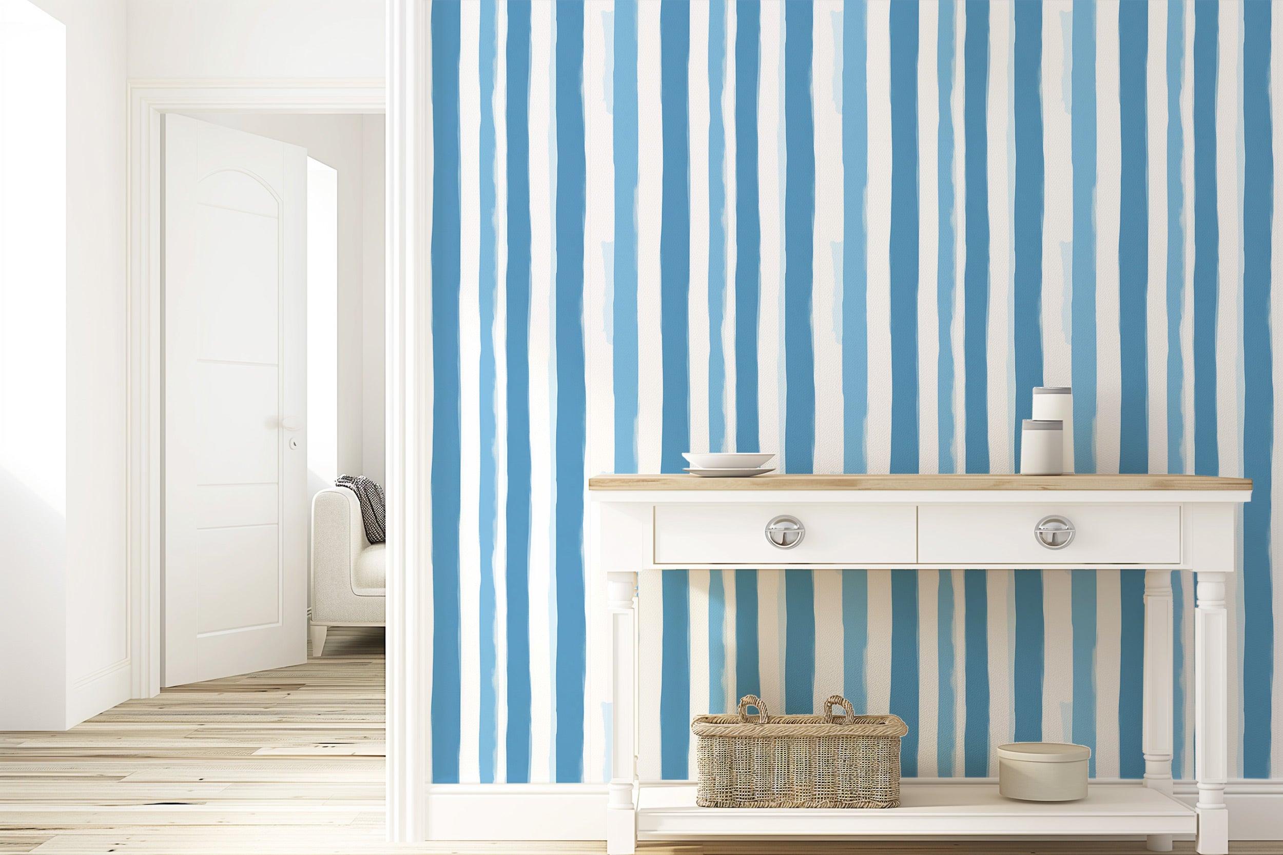 White-console table against blue and white watercolor stripe wallpaper, coastal striped peel and stick backdrop in a bright e