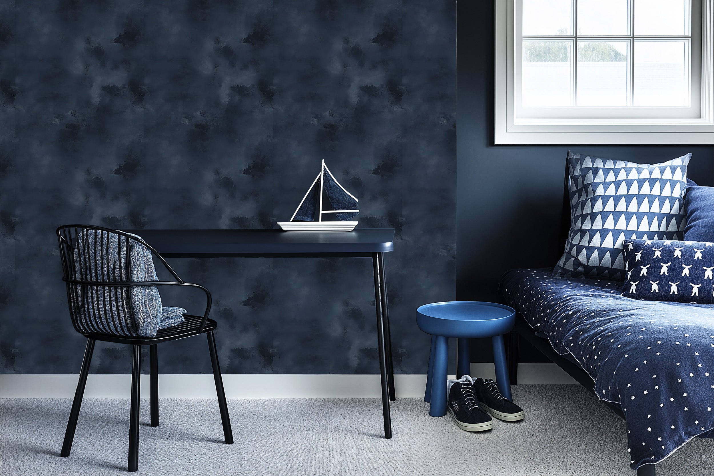 Navy blue abstract textured wallpaper in modern bedroom with desk, chair, blue stool, navy bedding and white-framed window, c