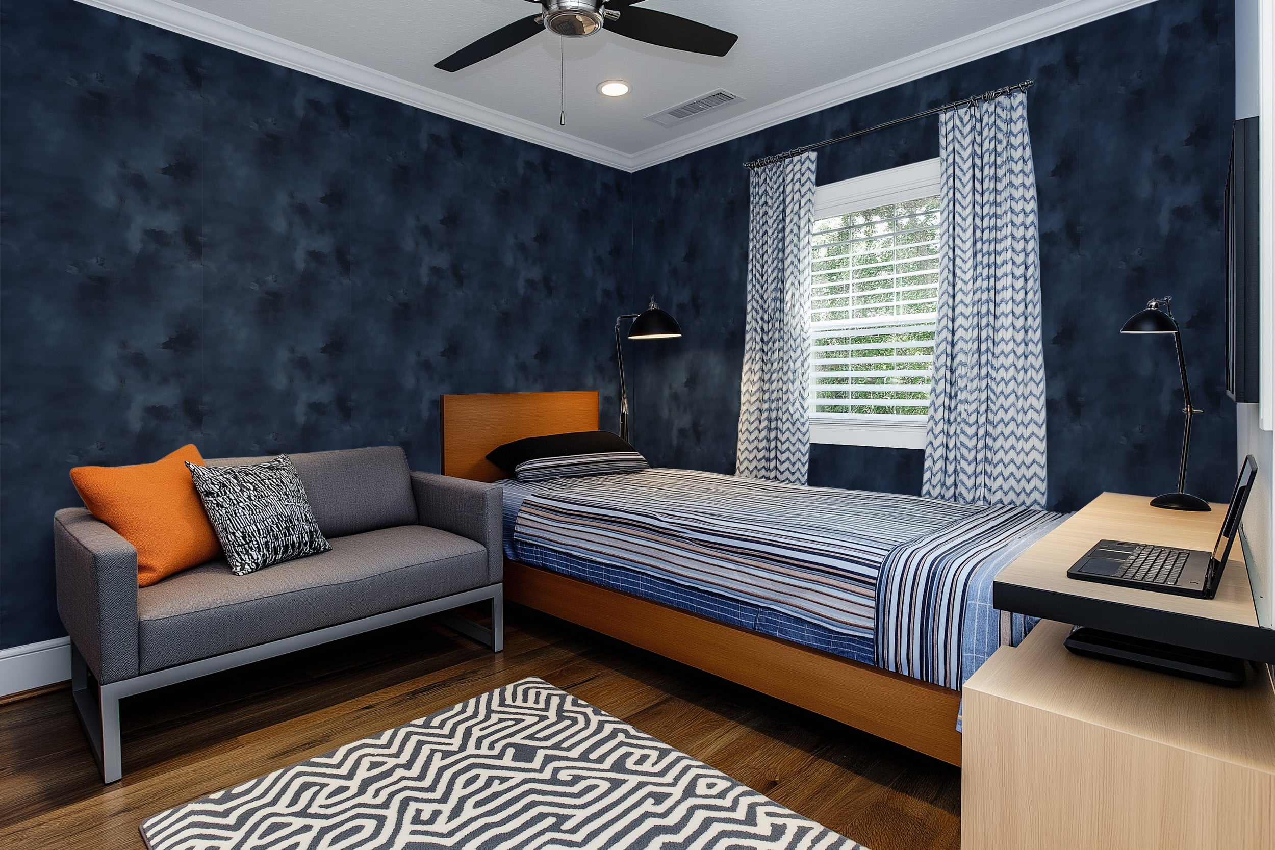 Navy blue abstract textured wallpaper in a modern bedroom with striped bedding, gray sofa, and chevron curtains in a cozy ren