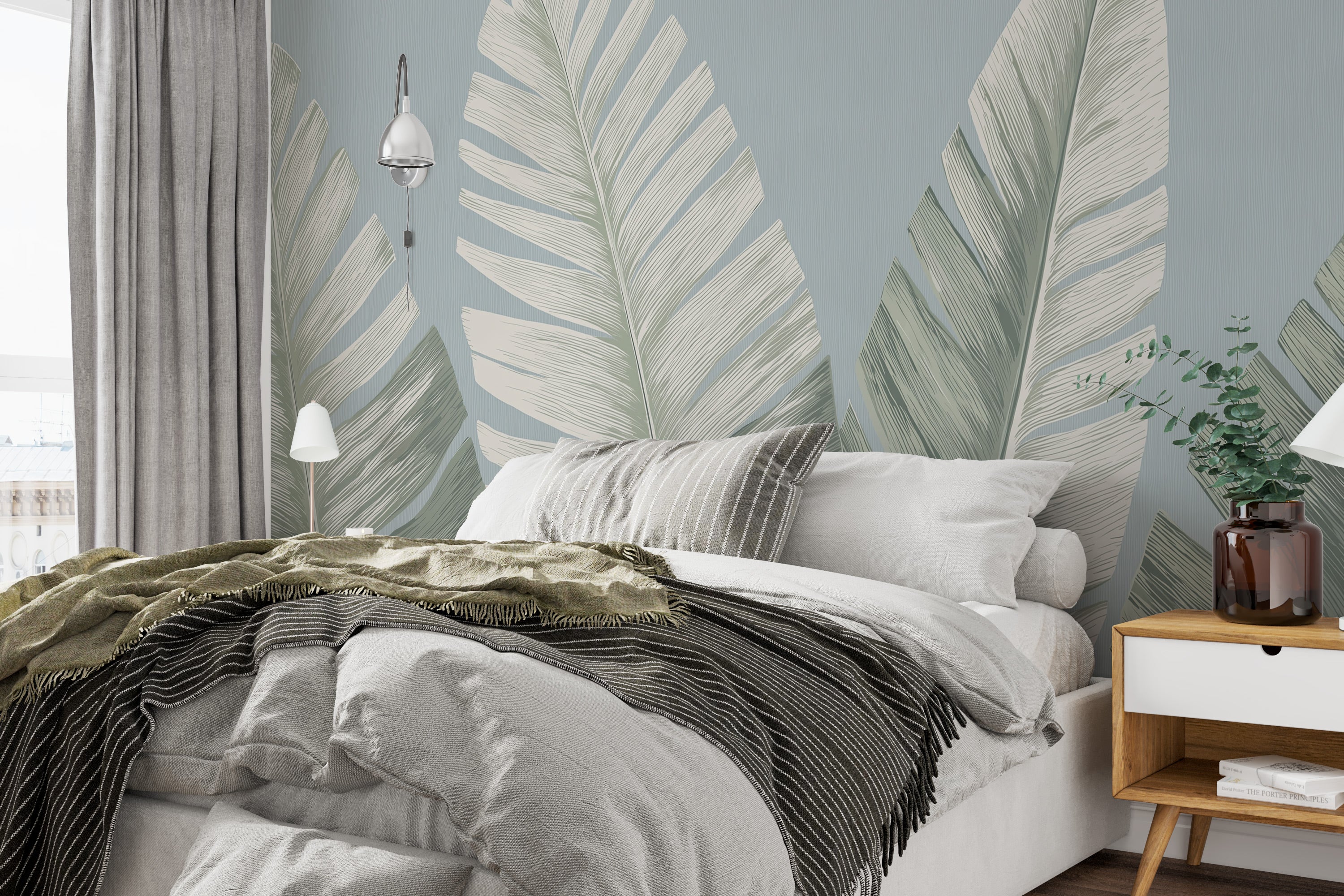 Tropical banana leaf mural in sage green and cream decorating a serene bedroom with large palm leaves on a soft blue backdrop