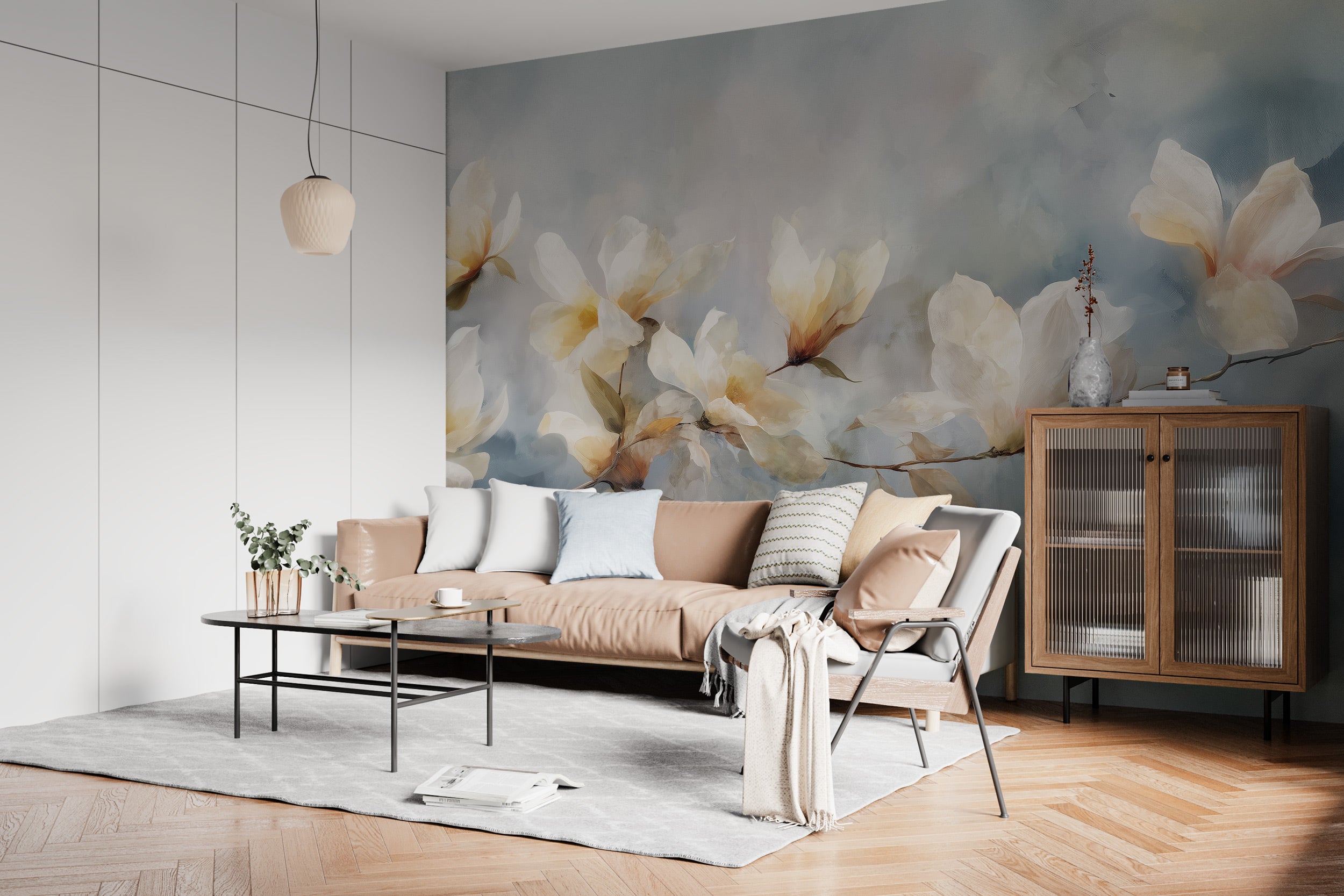 Watercolor magnolia branch mural in a bright living room with a peach sofa, pastel cushions, a wood cabinet, and a soft gray