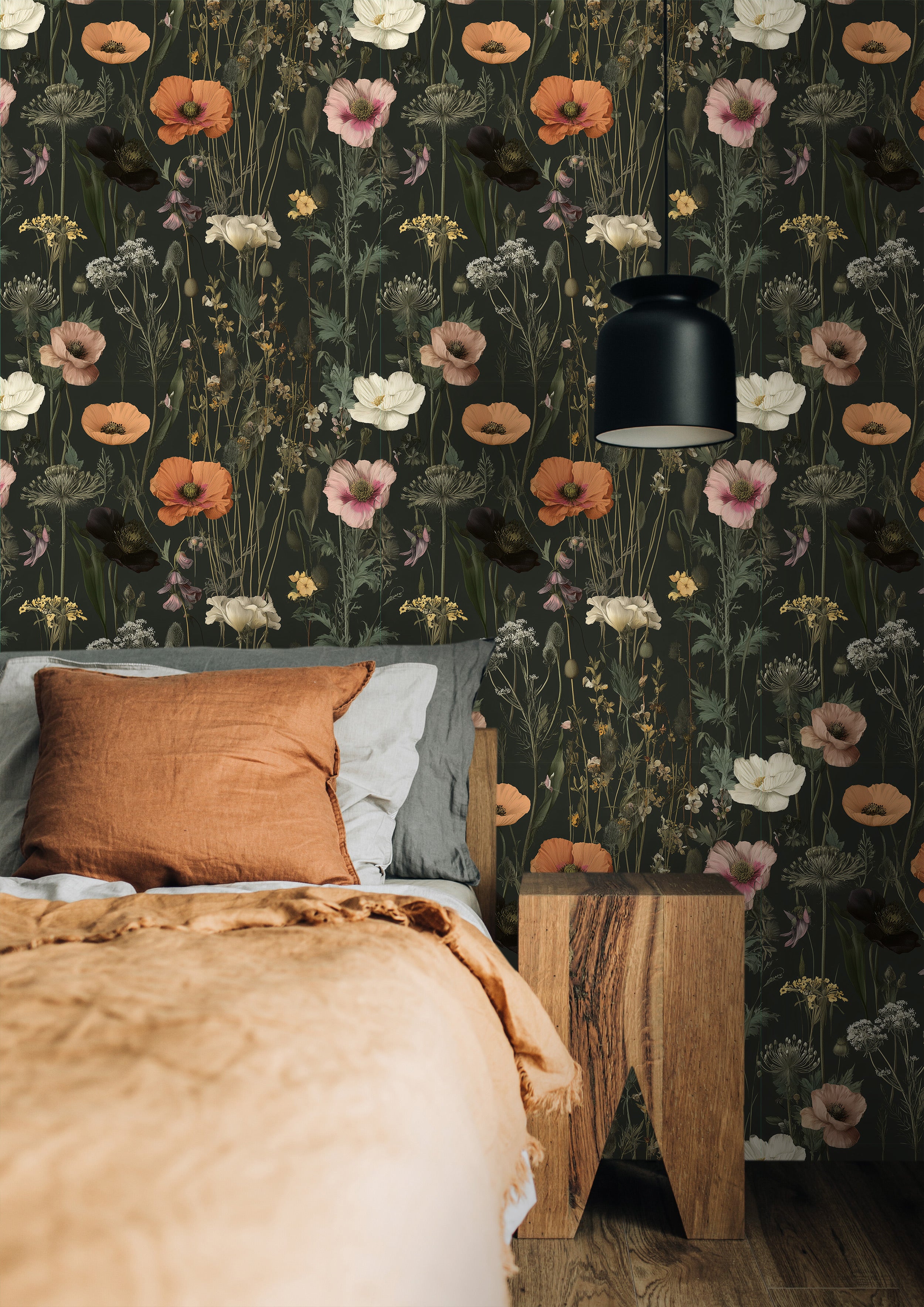 Dark moody green floral wallpaper with orange pink and cream wildflowers in a bedroom with a wooden nightstand and warm rust-