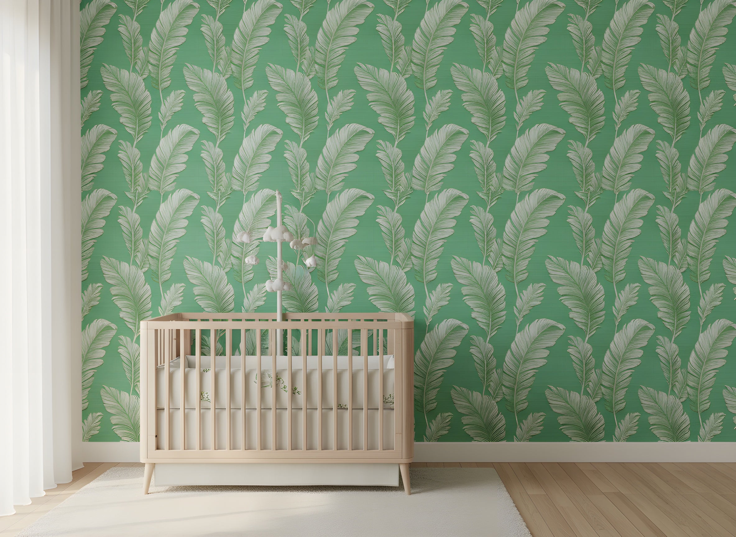 Green wallpaper with large white palm leaves in a tropical nursery featuring a light wood crib and soft natural light