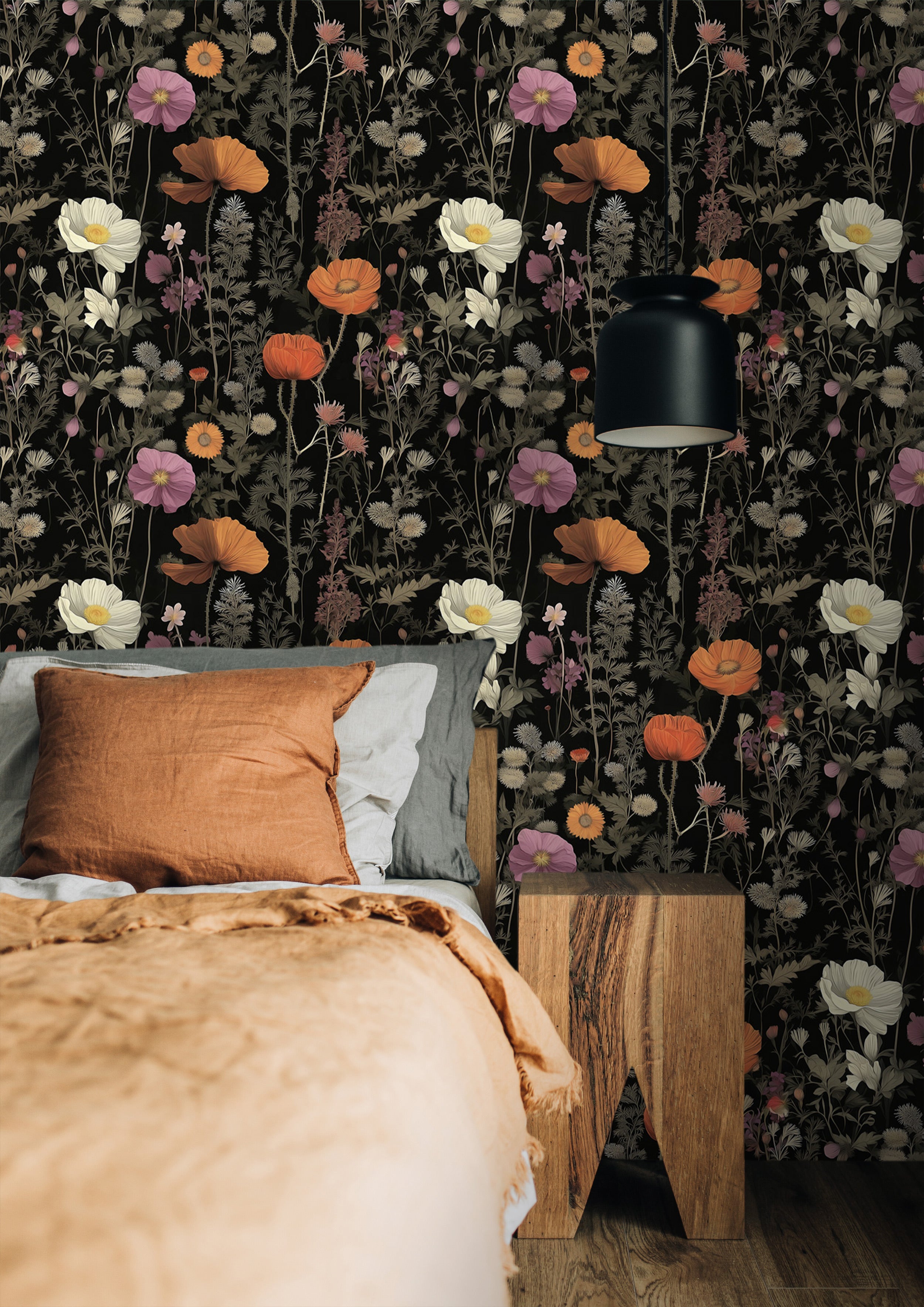 Dark botanical floral pattern wallpaper with orange poppies and delicate wildflowers on a black background shown behind a cozy bedroom with a wooden