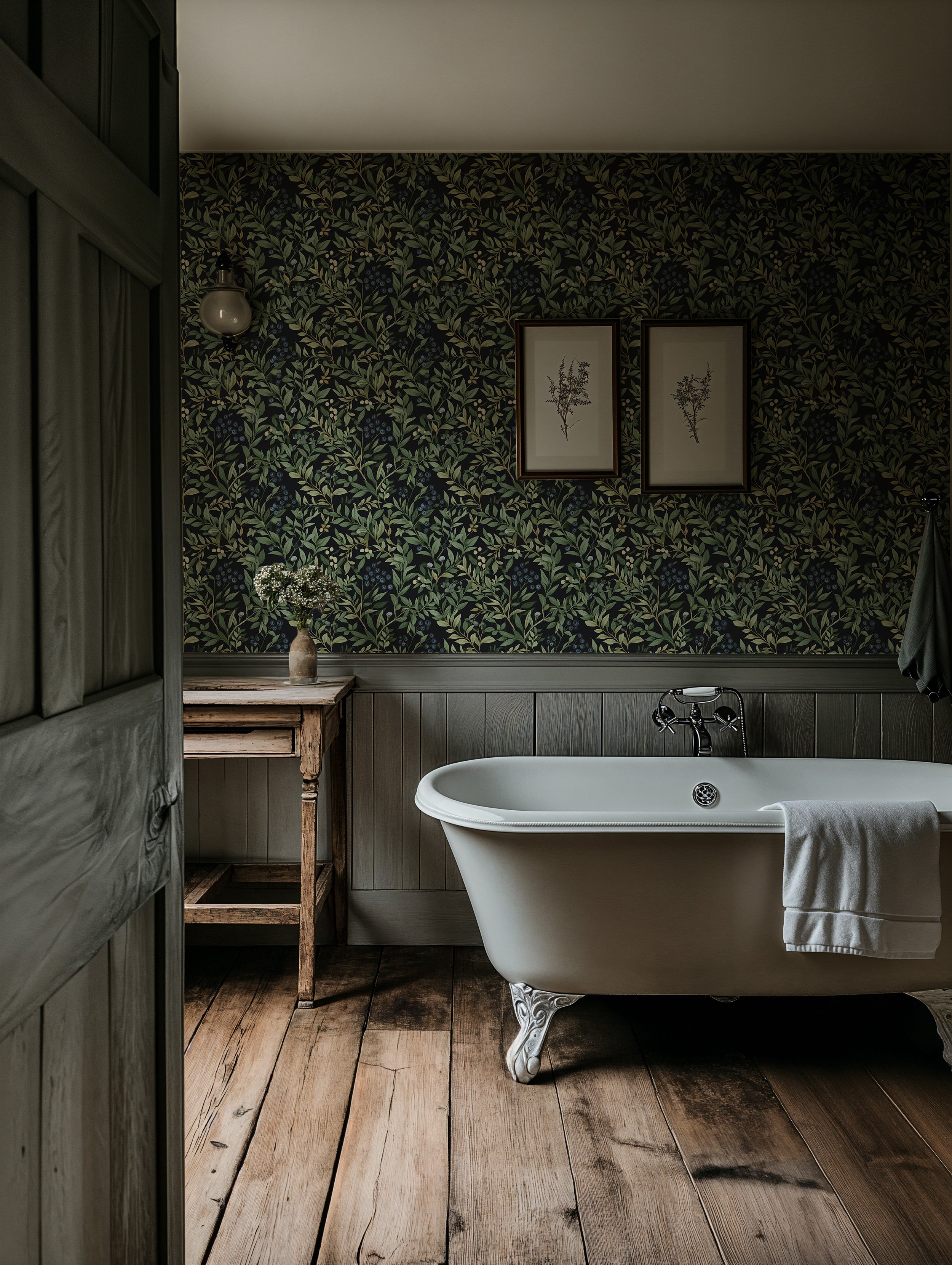 Botanical blueberry pattern wallpaper in a dark bathroom with a white clawfoot tub, rustic wood floor, and framed botanical a