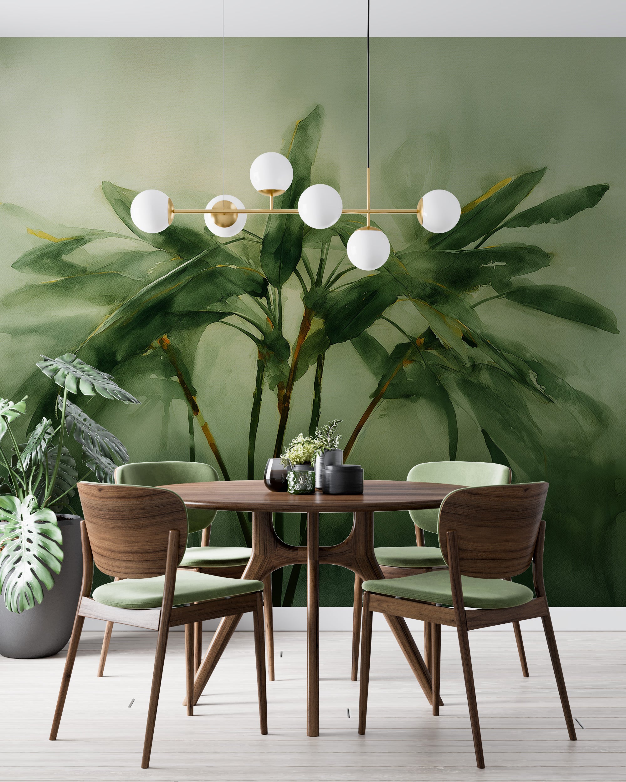Watercolor tropical palm mural in soft green tones behind a round wooden dining table with green chairs and a modern globe ch