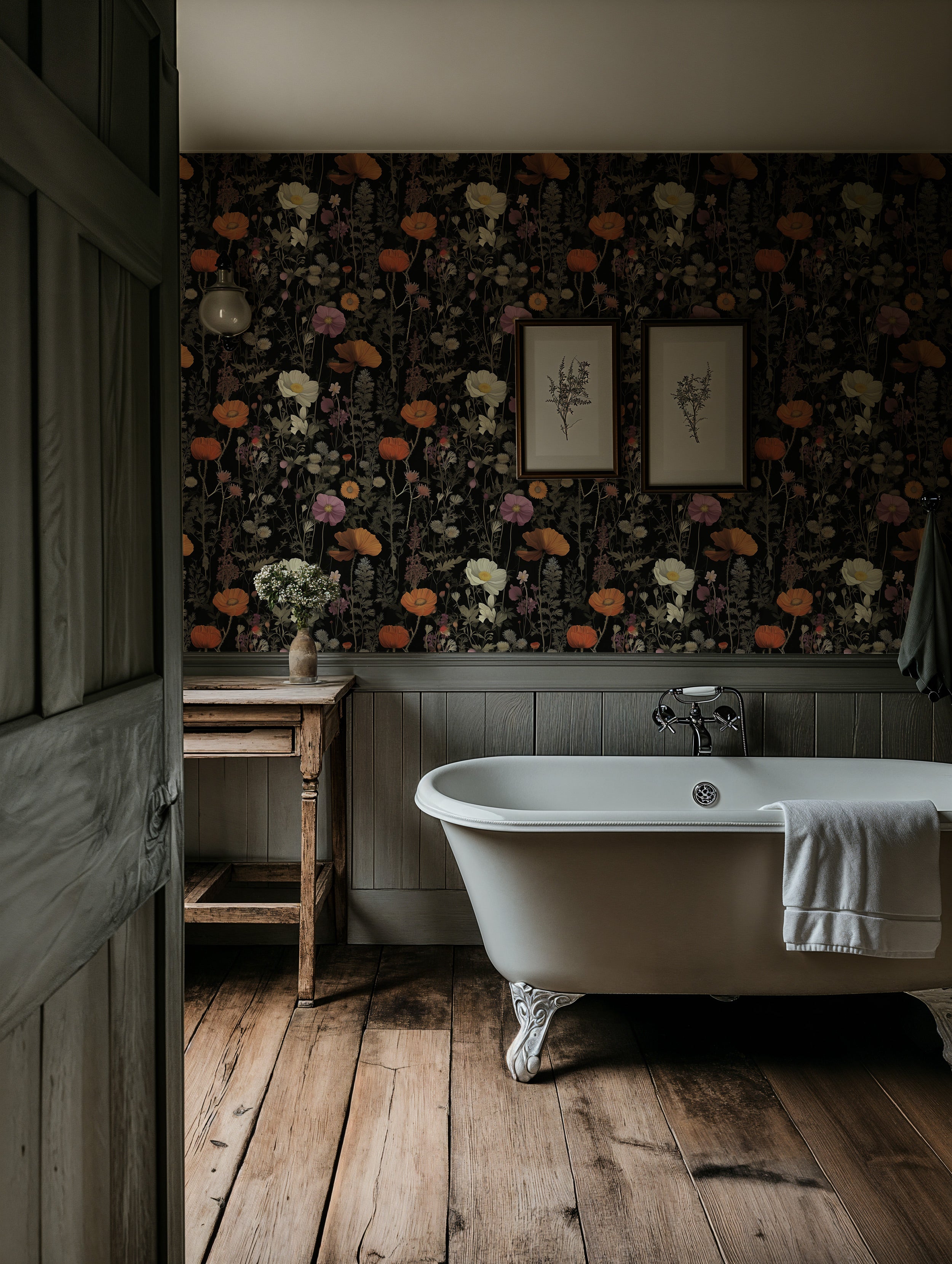Dark moody bathroom with a vintage dark floral wallpaper, white clawfoot tub, wooden flooring, and a rustic sink table accent wall with framed